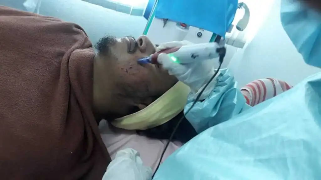 One of our clients receiving professional acne scar removal treatment in a clinical setting. The image shows a skincare specialist carefully performing the procedure while the client lies comfortably, highlighting a safe, hygienic, and results-focused treatment environment.