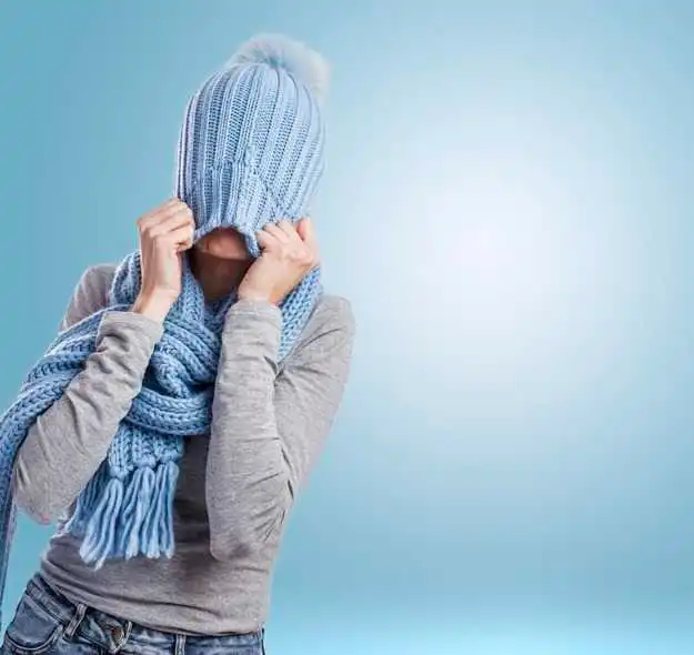 A person outdoors in cold weather with dry, slightly red skin on the face, highlighting the effects of excessive cold exposure. The image emphasizes how low temperatures can strip moisture from the skin, leading to dryness, irritation, and sensitivity.