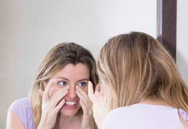 A client consulting with a skincare expert after noticing early signs of wrinkles. The image shows a professional examining the client’s facial skin in a clinical setting, emphasizing the importance of early treatment to maintain youthful and healthy skin.