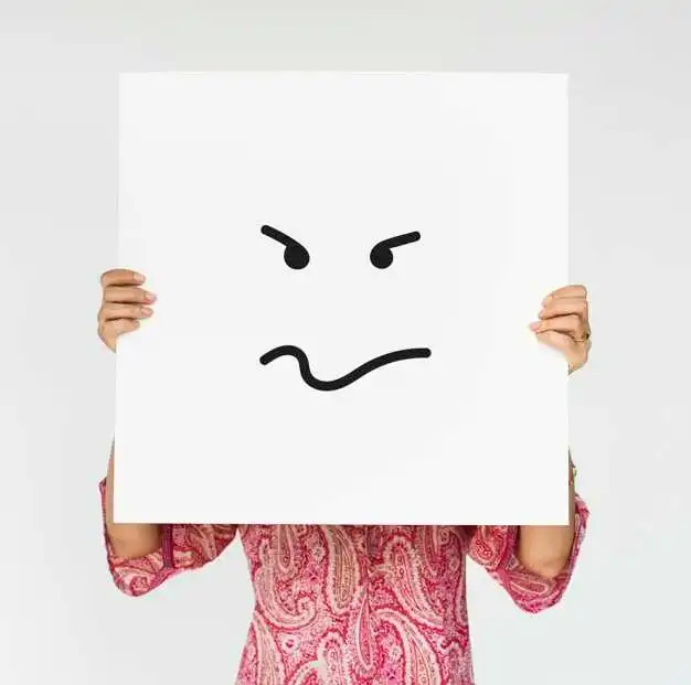 A person sitting with a tired and stressed expression, gently touching their face as visible signs of fatigue appear on their skin. The image highlights how pessimism and ongoing stress can negatively impact both mental well-being and overall skin health.